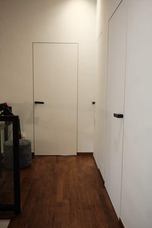 Hallway with flush white doors and built-in wardrobes over a timber floor - Terrace house A&A with new facade and full interior (3TBA) | Wong Lye, BCA General Builder Class 2, Singapore