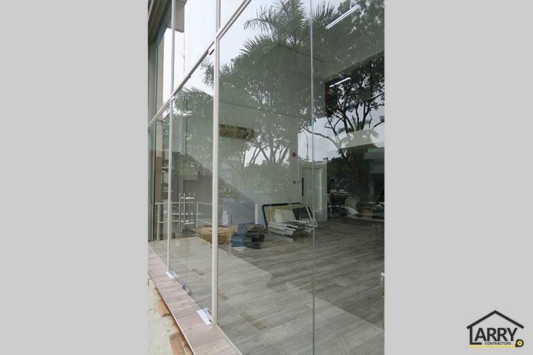 The glass wall seen from inside, trees reflected in the panels - Framed glass frontage and steel entrance stair for an industrial unit (M09) | Wong Lye, BCA General Builder Class 2, Singapore