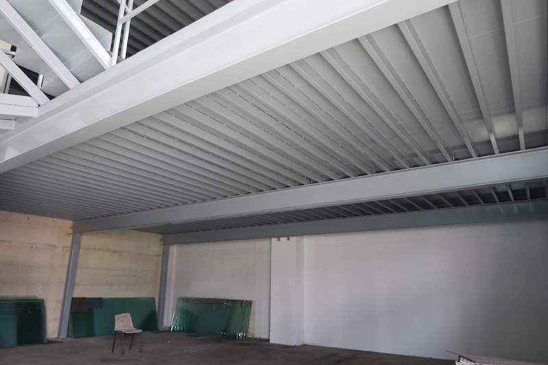 Underside of the mezzanine decking on grey steel beams and columns - Two-level steel mezzanine with staircases (HF0107) | Wong Lye, BCA General Builder Class 2, Singapore