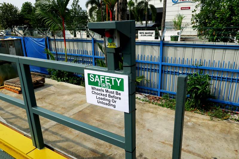 Steel railing at the dock edge with a safety sign fitted - Heavy-duty cable drum racking in a cable yard (TSE) | Wong Lye, BCA General Builder Class 2, Singapore