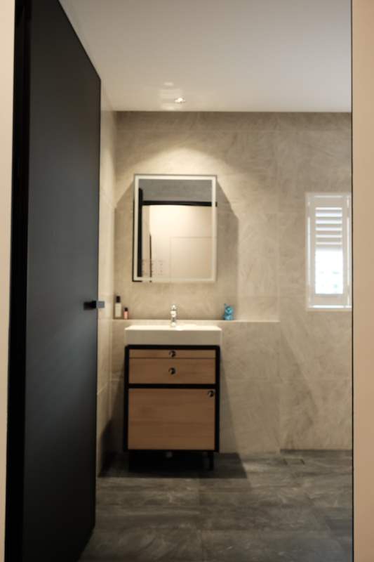 Bathroom vanity with a wall mirror and a timber drawer unit against grey tiled walls - Terrace house A&A with new facade and full interior (3TBA) | Wong Lye, BCA General Builder Class 2, Singapore