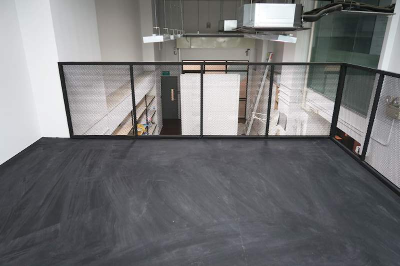 Loft floor looking out over the unit, mesh balustrade in front and exposed ducting at the ceiling - Steel loft platform with staircase in an industrial unit (Loft) | Wong Lye, BCA General Builder Class 2, Singapore