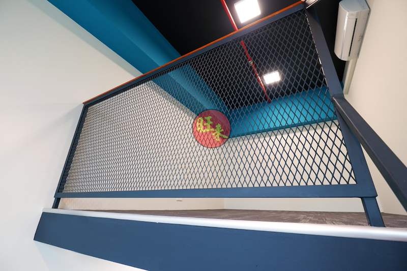 The loft's mesh railing seen from the staircase, blue wall behind - Office loft with a cantilevered steel and timber staircase (HomeOffice) | Wong Lye, BCA General Builder Class 2, Singapore