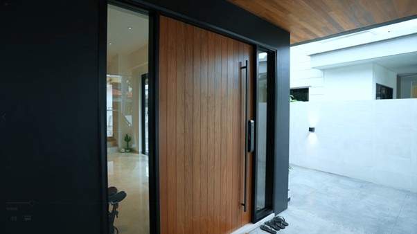 Timber pivot front door with a black frame and glass side panel at the entrance - Landed house A&A with new facade, staircase and interiors (39EW) | Wong Lye, BCA General Builder Class 2, Singapore