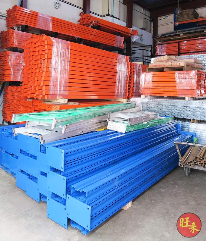 Stacked blue upright frames with orange beams bundled on top - Pallet racking beams and frames stacked in a warehouse (M12) | Wong Lye, BCA General Builder Class 2, Singapore
