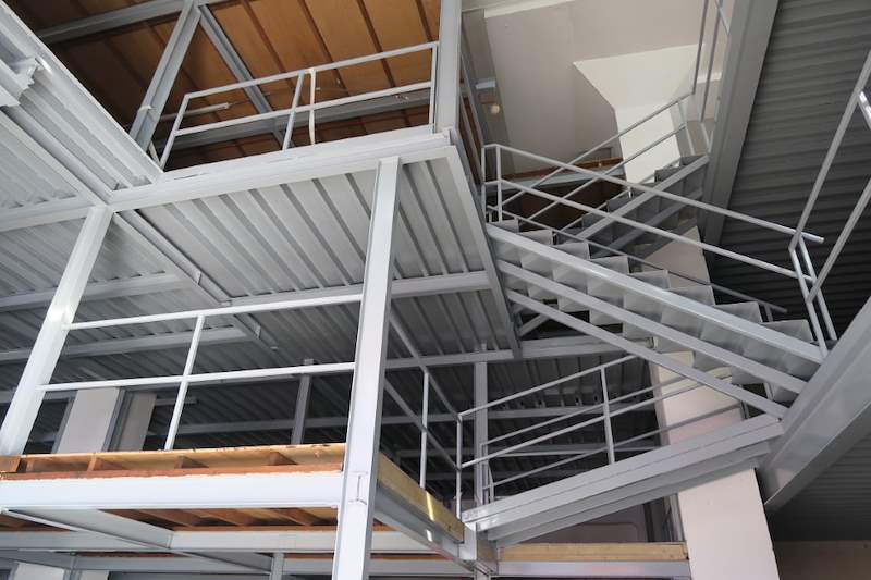 Looking up through the steel framing and the staircase flights - Two-level steel mezzanine with staircases (HF0107) | Wong Lye, BCA General Builder Class 2, Singapore