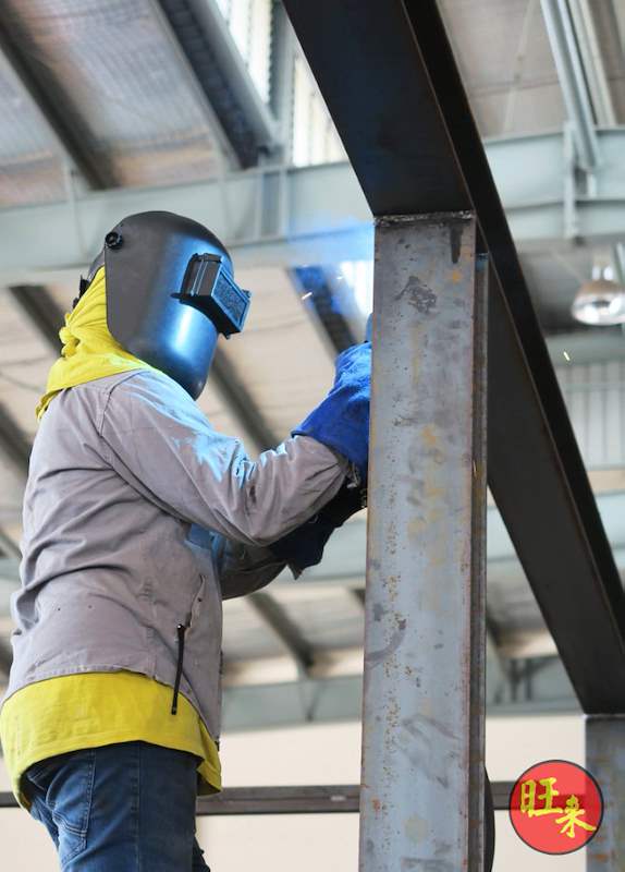 Welder working on a steel column joint for the racking frame - Heavy-duty cable drum racking in a cable yard (TSE) | Wong Lye, BCA General Builder Class 2, Singapore