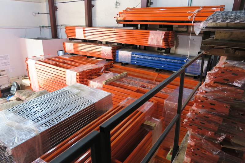 Orange beams, blue uprights and galvanised deck panels stacked ready - Pallet racking beams and frames stacked in a warehouse (M12) | Wong Lye, BCA General Builder Class 2, Singapore