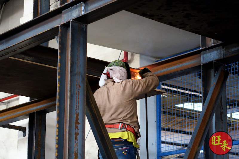 Welder at a beam-to-column connection of the steel frame - Heavy-duty cable drum racking in a cable yard (TSE) | Wong Lye, BCA General Builder Class 2, Singapore