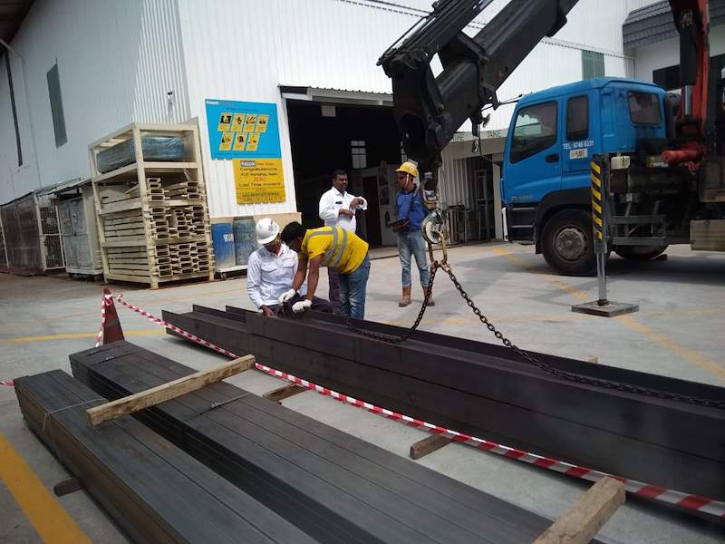 Steel beams lifted off the lorry on crane chains, workers guiding the load - Steel mezzanine platform in a factory (M22) | Wong Lye, BCA General Builder Class 2, Singapore