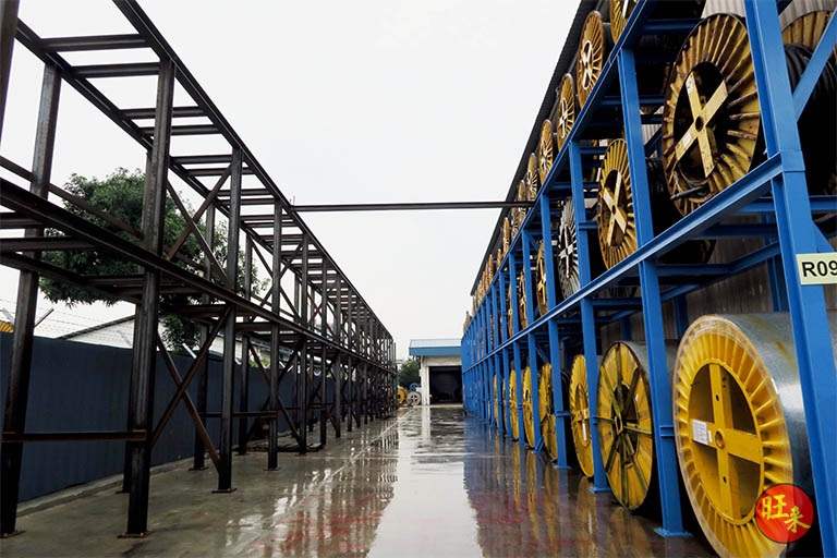 Blue drum racks with a dark steel frame in the foreground - Heavy-duty cable drum racking in a cable yard (TSE) | Wong Lye, BCA General Builder Class 2, Singapore
