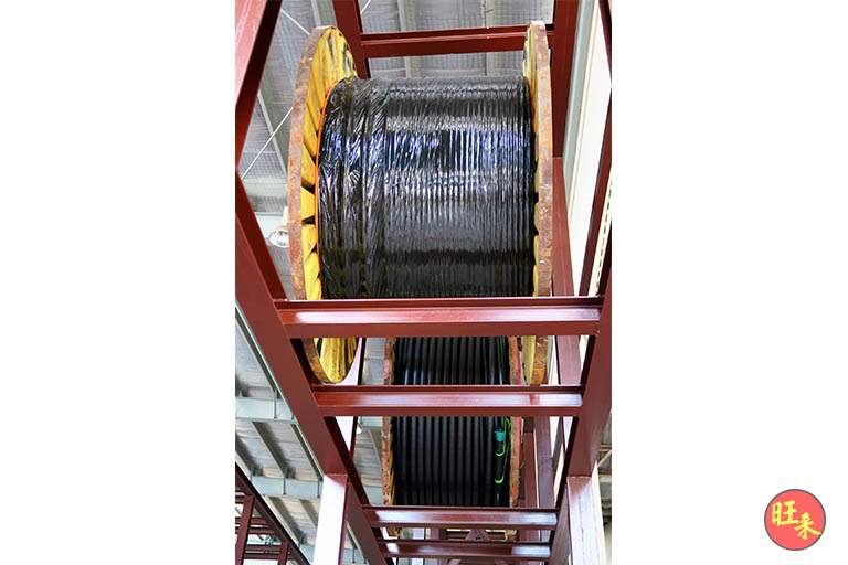 Cable drum seated in a red-oxide primed steel rack bay, seen from below - Heavy-duty cable drum racking in a cable yard (TSE) | Wong Lye, BCA General Builder Class 2, Singapore