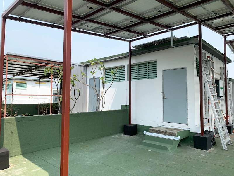The steel canopy over the rooftop terrace with a planter and step beneath it - Rooftop steel canopy carrying solar panels (M28) | Wong Lye, BCA General Builder Class 2, Singapore