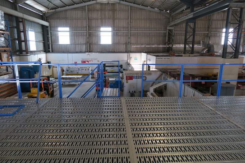 Mezzanine deck with blue railings beneath the factory roof trusses - Steel mezzanine platform in a factory (M22) | Wong Lye, BCA General Builder Class 2, Singapore