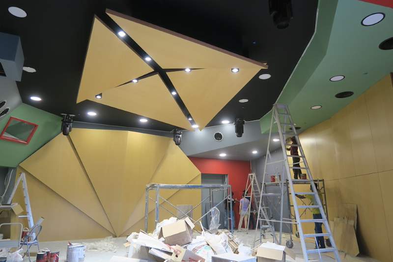 Red wall and timber panels with a ladder and materials during works - Music rehearsal studio fit-out with a faceted timber ceiling (Studio) | Wong Lye, BCA General Builder Class 2, Singapore
